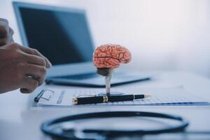 Arzt erklären Gehirn Funktionen zu geduldig auf Modell- im Büro. foto