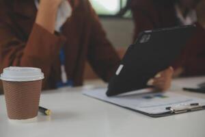 Zusammenarbeit mit Geschäft Menschen Analyse Kosten Graph auf das Schreibtisch im das Treffen Zimmer. das Geschäft Mannschaft besprochen Treffen und Einweisung Strategien. Verhandlung, Analyse, Diskussion foto