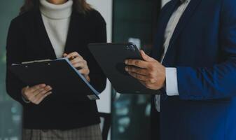 asiatischer geschäftsmann und geschäftsfrau des unternehmers, die neues geschäftsprojekt in tablette in modernem treffen im modernen büro, asiatisches geschäfts-beiläufiges konzept besprechen. foto