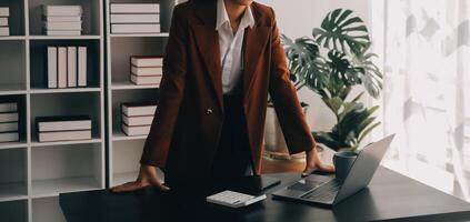 Porträt einer jungen asiatischen Freiberuflerin arbeitet an ihrem Job auf einem Computertablett im modernen Büro. Durchführung von Buchhaltungsanalyseberichten über Immobilieninvestitionsdaten, Konzept von Finanz- und Steuersystemen. foto