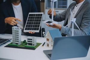 zwei jung Ingenieure Sachverstand im Solar- Zelle Installation Treffen und Diskussion im das Arbeit. Planung zu Installieren Solar- Photovoltaik Paneele auf Dach oben im das Büro Zimmer mit Fabrik Gebäude planen. foto