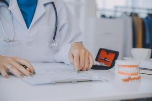 zahnärzte diskutieren zahnprobleme und melden den patienten ein röntgenbild auf einem laptop-bildschirm. foto