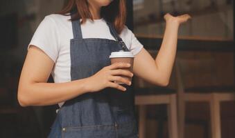 Startup erfolgreicher Kleinunternehmer SME Schönheitsmädchen steht mit Tablet-Smartphone im Café-Restaurant. Porträt der Barista-Café-Besitzerin mit asiatischer Bräune. KMU-Unternehmer-Verkäufer-Geschäftskonzept foto