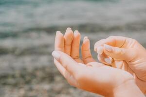 Frau Essen milchig Mandel Nüsse. ein jung kaukasisch Frau Hacken frisch Grün Mandel nach Morgen Fitness Yoga in der Nähe von Meer. nur Hände sind sichtbar. gesund vegan Lebensmittel. schleppend Bewegung. schließen oben foto