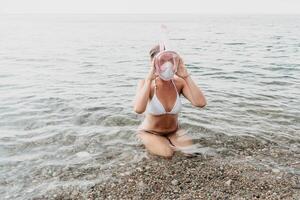 jung glücklich Frau im Weiß Bikini und tragen Rosa Maske bekommt bereit zum Meer Schnorcheln. positiv lächelnd Frau entspannend und genießen Wasser Aktivitäten mit Familie Sommer- Reise Ferien Ferien auf Meer. foto