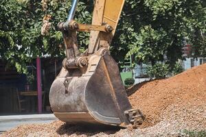 Bagger graben Boden und Stein auf Konstruktion Seite? ˅ foto