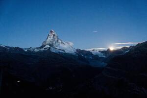 majestätisch Matterhorn Berg mit Sterne und Mondlicht scheint im das Dämmerung beim Zermatt, Schweiz foto