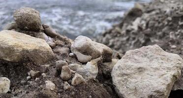 Felsen Formation durch Strand mit Wasser im Hintergrund foto