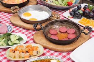 Kochen ein Gericht von Frühstück Würstchen im ein schwenken auf ein hölzern Tabelle foto