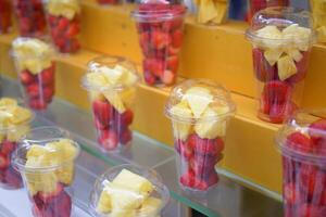 Ananas, Kiwi und Erdbeeren In. Plastik Container Verkauf beim Geschäft foto