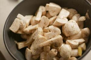 frisch Champignons Pilz im ein Weiß Schüssel auf Tabelle foto