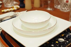 runden Schüssel oder Keramik Teller auf Serviette auf hölzern Tisch. foto
