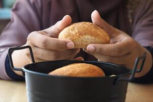 Frau Hand wählen gebacken Brötchen auf Tabelle foto