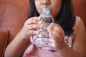 Kind Trinken Flasche von Wasser foto