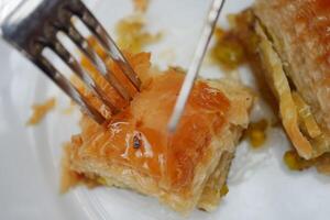 Schneiden Türkisch Dessert Baklava mit Messer foto