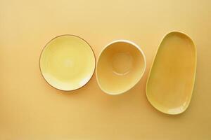 oben Aussicht von anders gestalten Gelb Farbe Schüssel oder Keramik Teller foto