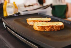 Scheibe von Knoblauch Brot auf das heiß Pfanne. foto