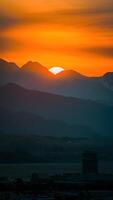 ai generiert Sonne setzt hinter majestätisch Berge, Gießen ein golden Farbton Vertikale Handy, Mobiltelefon Hintergrund foto