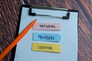 Konzept von National die Pension planen schreiben auf klebrig Anmerkungen isoliert auf hölzern Tisch. foto