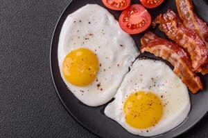 englisches frühstück mit spiegeleiern, speck, bohnen, tomaten, gewürzen und kräutern foto