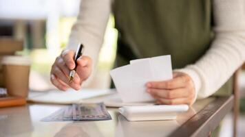 ein weiblich klein Geschäft Inhaber rechnen ihr monatlich Kosten, Überprüfung Rechnungen Quittungen. foto