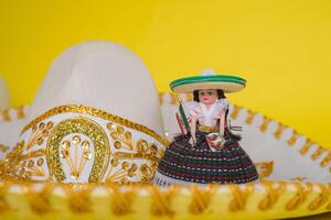 Puppe Darstellen das Mexikaner Frau und Mariachi Hut auf Gelb Hintergrund. foto