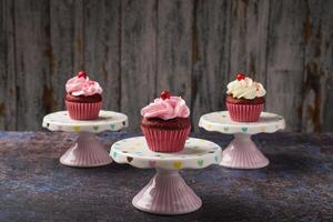 Cupcakes auf klein Keramik Teller mit hölzern Unterseite mit Kopieren Raum. Produkt Foto. foto