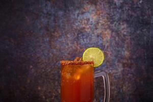 Michelada, typisch Mexikaner Cocktail auf ein hölzern Tisch. Cocktail basierend auf Bier. foto