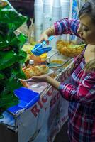 Mexikaner Frau vorbereiten ein gekocht Mais, typisch Mexikaner Straße Lebensmittel. Essen Stall. Elote. foto