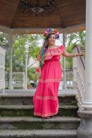 Mexikaner Frau tragen gestickt Kleid und lele Puppe Stirnband. draussen Porträt. cinco de Mayo Feier. foto