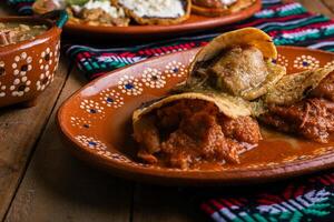 Gorditas de Chicharron im Grün Soße und rot Soße. Mexikaner Lebensmittel. foto