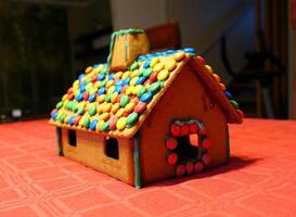 ein hausgemacht Lebkuchen Haus mit das Dach bedeckt mit Pralinen foto