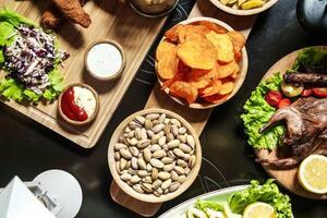 Tabelle mit Platten von Essen und Schüssel von Chips foto