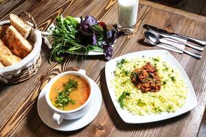 hölzern Tabelle mit Essen Platten und Suppe Schüssel foto