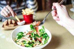 Person Essen Salat mit Gabel foto