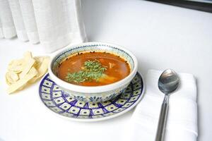 Schüssel von Suppe mit Löffel und zwei Salz- Schüttler foto