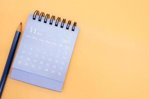 2024 November Kalender und Bleistift isoliert auf Orange Hintergrund. Planung zum Geschäft oder Reise Konzept. Kopieren Raum zum Text foto