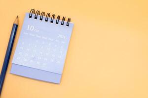 2024 Oktober Kalender und Bleistift isoliert auf Orange Hintergrund. Planung zum Geschäft oder Reise Konzept. Kopieren Raum zum Text foto
