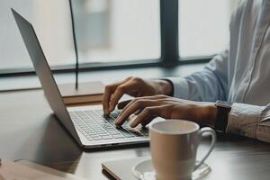 korporativ Geschäftsmann im passen Arbeiten auf Laptop mit ein Kaffee Becher neben ihm im seine Büro foto