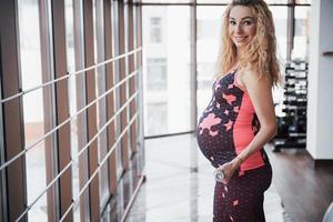 das Konzept einer schwangeren Frau Sport und Fitness und führt einen gesunden Lebensstil im Fitnessstudio