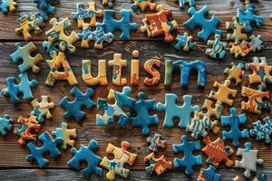 bunt Puzzle Stücke Rahmen und Wort Autismus auf hölzern Hintergrund. Welt Autismus Bewusstsein Tag Konzept. foto
