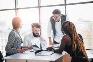 eine Gruppe multinationaler beschäftigter Leute, die im Büro arbeiten foto