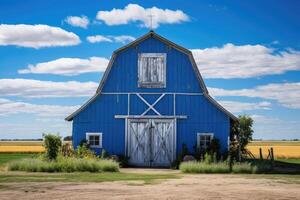 ein klassisch Blau Scheune mit Weiß trimmen gelegen inmitten ein riesig Landschaft Landschaft unter ein Blau Himmel mit Wolken foto