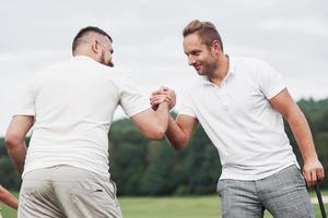 sieht nach einem Deal aus. Seitenfoto von zwei Männern, die die Hände halten und eine starke Freundschaft zeigen foto