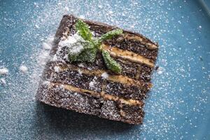 das Brownie im ein Teller auf ein Blau Tisch. foto