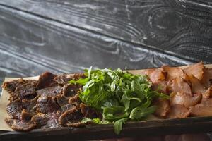 ein Fleisch Teller auf ein hölzern Hintergrund. foto