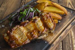 gebraten Kartoffeln mit gegrillt Fleisch auf ein hölzern Tisch. foto