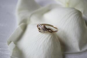 golden Ring auf Weiß Blütenblätter von Rosen. foto