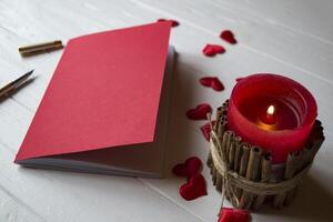 rot Notizbuch, Kerze und Liebe Herzen auf ein Schreibtisch. foto