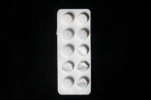 ein Weiß Pille Flasche mit ein schwarz Hintergrund foto